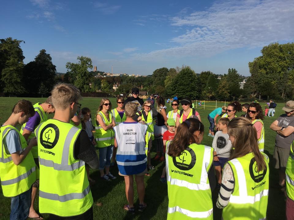 Volunteers in high vis jackets being briefed ready to help at a parkrun