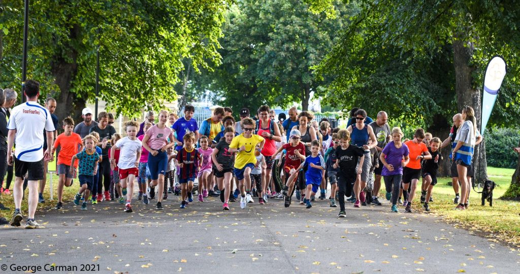 Children running across the start line of the first Hillsborough junior parkrun